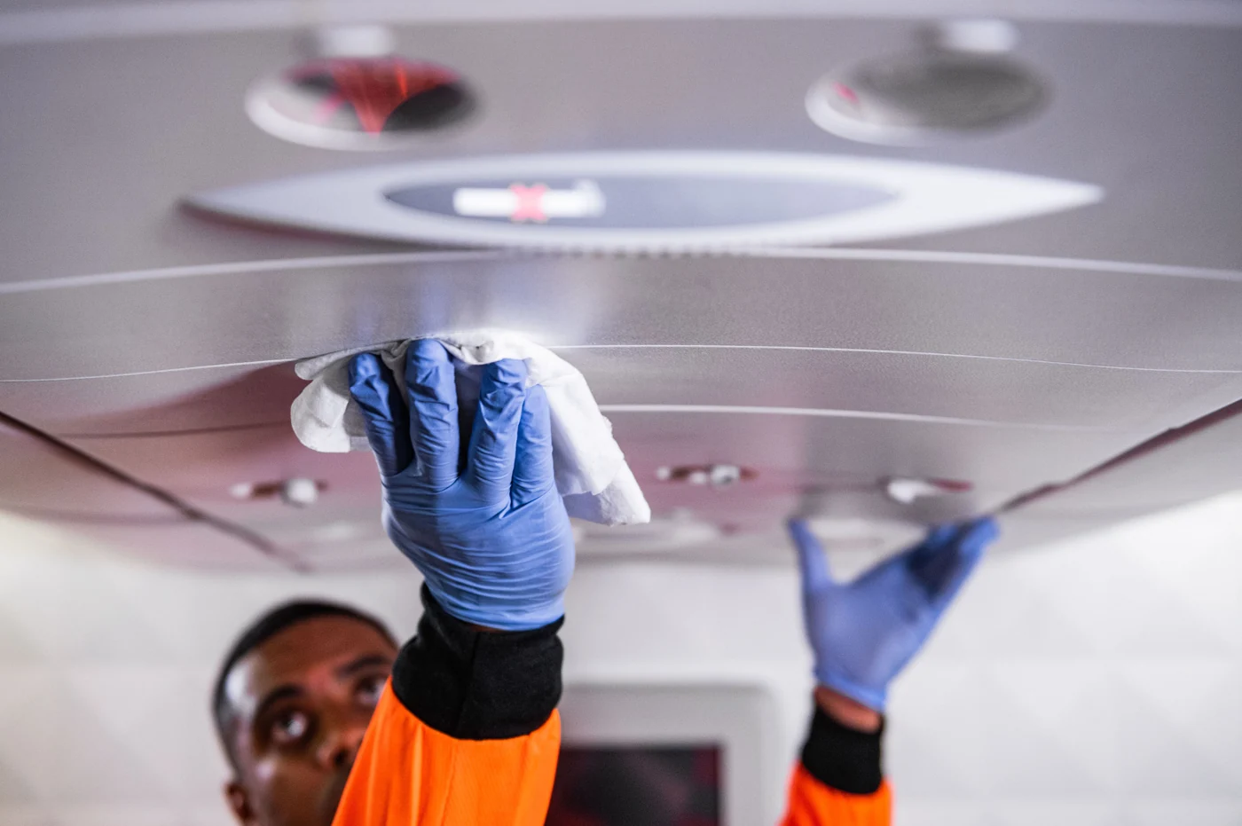 Real photograph of detailed cleaning on a commercial aircraft cabin surface